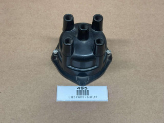 Distributor Cap ACR1954, black plastic engine distributor cap with multiple ignition wire connectors, used automotive part displayed on a plain surface.
