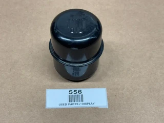 Oil Fill Breather Cap Without Clip, display image of a black oil fill breather cap without clip on a beige surface.