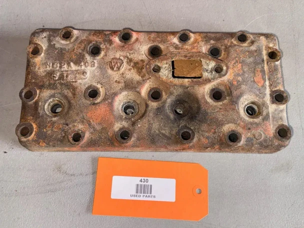 Allis-Chalmers Used Allis-Chalmers G Cylinder Head, rusty and used condition with multiple bolt holes and a rectangular opening.