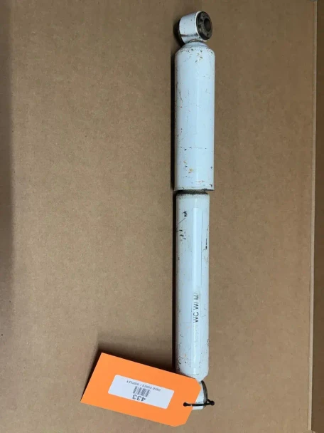 Seat Shock Absorber Fits Monroe Seat, display image of a white shock absorber for a vehicle seat with a tag labeled '433' placed on a brown surface.