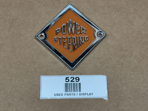 Allis Chalmers Power Steering Wheel Emblem D14 D15 D17, display image of a vintage diamond-shaped metal emblem with orange background and raised silver lettering and border.