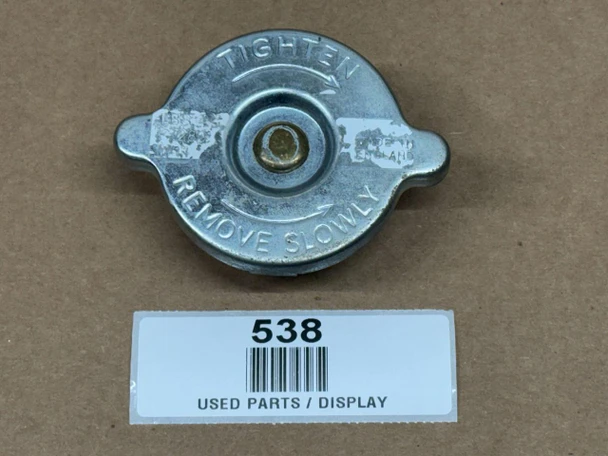 Allis-Chalmers 4 PSI Radiator Cap, display model, metallic with embossed instructions 'Tighten' and 'Remove Slowly' around the central screw.