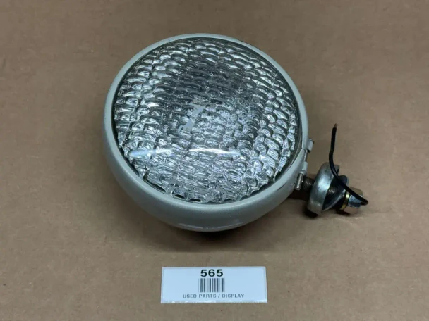 Headlight Assembly 12 Volt for Allis-Chalmers and Ford, display of a round headlight with a reflective glass surface and wiring attached, used as a replacement part for tractors.