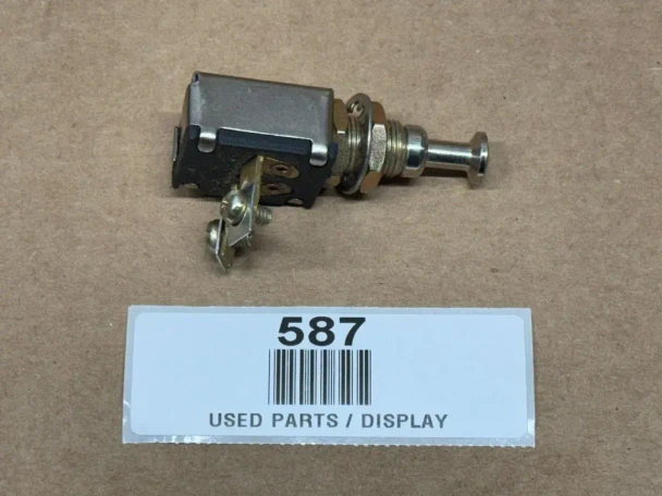 Universal 2 Position Push Pull Switch, display image of a used electrical switch component with metal parts and black plastic housing.