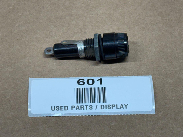 Fuse Holder 20 Amp, display image of a used electrical fuse holder with a black and metallic design on a brown surface with a label.