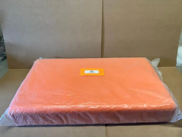 Allis Chalmers B C Bottom Seat Cushion Orange (Display), orange cushioned seat with padding inside, in transparent plastic packaging, on a cardboard surface.