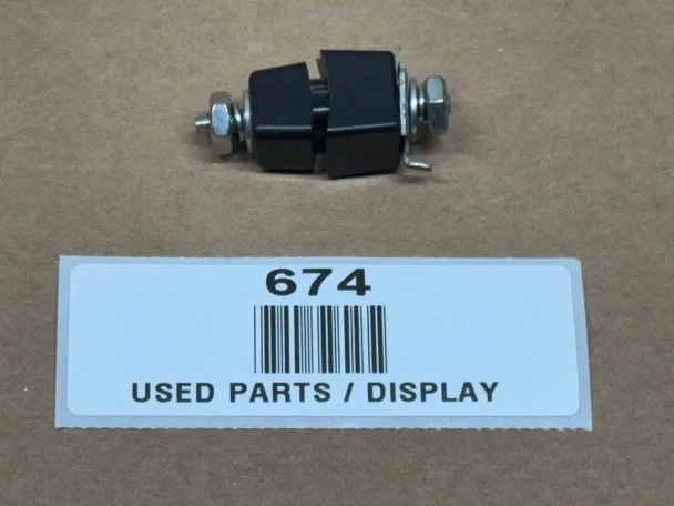 Delco Distributor Terminal Insulator Assembly Square Style - AB-500D, used part displayed with a black insulator and metal terminal components on a brown surface.