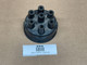 Allis-Chalmers D19 Delco Distributor Cap ACR1957, display view of a used black distributor cap with multiple ignition wire connectors, on a plain brown background.