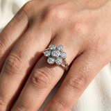 Flower cluster diamond ring worn on model's hand, bezel set 14kt white gold with natural diamonds
