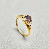 Convex-cut natural tanzanite with burgundy axis in 14kt yellow gold close-up