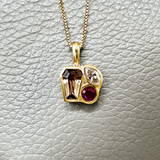 Warm-toned tanzanite center with ruby and diamond accents 14kt yellow gold
