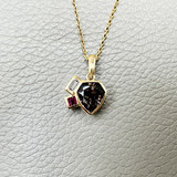 Custom spear-cut tanzanite with baguette diamond and ruby 14kt yellow gold close-up