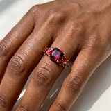 Garnet ruby and red spinel cocktail ring worn on model's hand, 14kt yellow gold vintage multi-stone design
