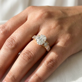 Natural oval diamond engagement ring baguette round accents worn on hand yellow gold