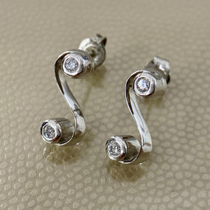 Treasured & Co. 14kt white gold swirl earrings adorned with 0.24tcw diamonds, perfect for a stylish and sophisticated look.