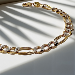 close-up diamond-cut Figaro links on gold bracelet close-up diamond-cut Figaro links on gold bracelet