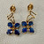 Treasured & Co. 14kt yellow gold earrings showcasing a flower design with 0.68tcw sapphires in a delicate dangling style.