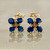 Stylish sapphire flower dangle earrings with 0.68tcw gemstones, designed in luxurious 14kt yellow gold Treasured & Co.