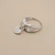 Heart diamond ring side profile showing 14kt white gold band and attached dangling heart charm