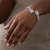 Bypass open bangle 14kt white gold with baguette and round stone halo close-up