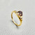 Convex-cut natural tanzanite with burgundy axis in 14kt yellow gold close-up