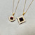 Garnet And diamond halo pendant necklace on display