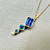 Emerald-cut tanzanite with Asscher blue topaz pendant 14kt yellow gold close-up