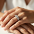 Three stone princess cut diamond engagement ring white gold halo worn on hand