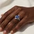 Vintage inspired oval sapphire diamond engagement ring worn on models hand