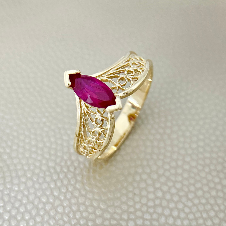 Stunning 0.60ct marquise gold ring with lab-created ruby, set on a filigree design in 14kt yellow gold. A unique ring for women from Treasured & Co., Astoria, NY.