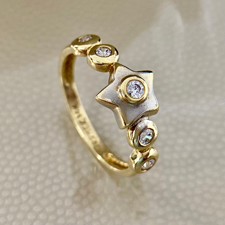 0.26ct star fashion ring, made in two-tone 14kt white and yellow gold with a matte finish and bezel set zirconias. A unique ring for her by Treasured & Co., Astoria.