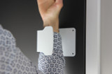 The Frost 1148 Hands-Free Door Pull in grey, showcasing its practical design as it is being used with a wrist, demonstrating a hygienic way to open doors without hand contact.