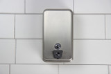 The Frost 708A is a robust vertical stainless steel liquid soap dispenser with a secure lock at the bottom, suitable for maintaining hygiene in high-use commercial or public restrooms.