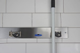 Frost 1113 Stainless Steel Mop and Broom Holder, a practical and robust storage solution for maintaining an orderly and efficient cleaning supply area.