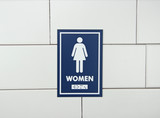 Frost 961 female washroom signage in a bold blue with white pictogram and Braille, ensuring clear and accessible directions for women's restrooms.