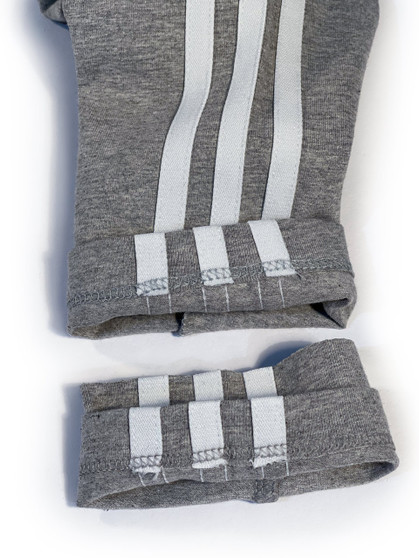Close-up example of Adidas track pant hem that has been professionally shortened with hemming knit pants alterations service using an industrial coverstitch sewing machines.
