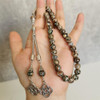 Brown and green stone prayer beads displayed on black background