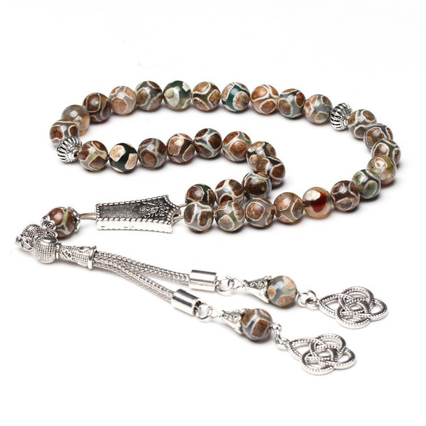 Close-up of round patterned agate prayer beads with silver spacers
