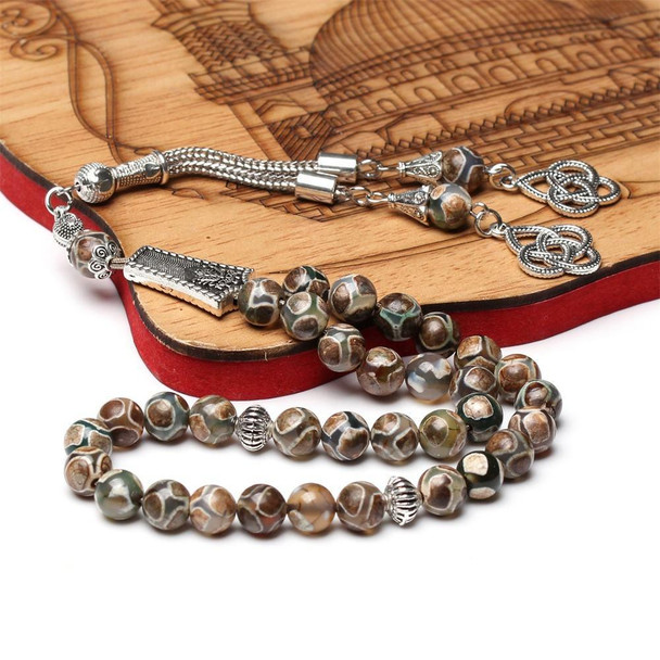 Islamic prayer beads displayed on a wooden mosque-patterned stand