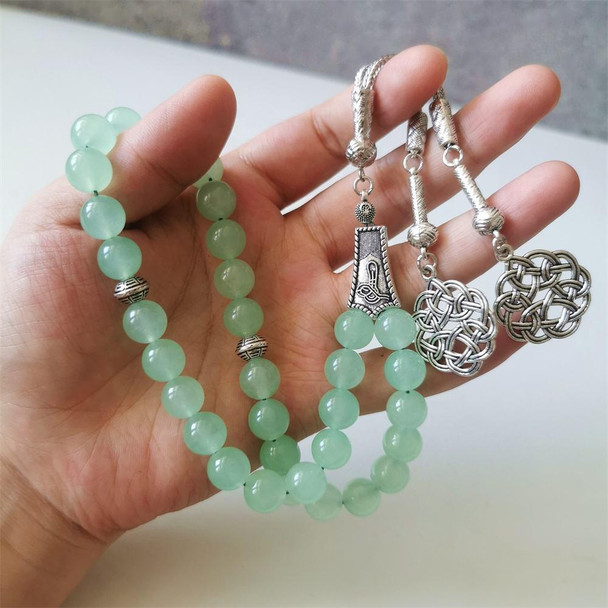 Green jade tasbih prayer beads displayed with silver tassel