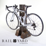 White Orbea bike on custom wood timber and steel bike stand.