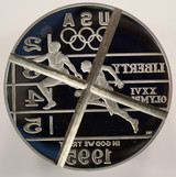 1995 proof track and field Olympic die, used for striking silver dollar track and field commemorative coins for the 1995/1996 Atlanta Olympic games. The die was used for striking some of those coins, and then was retired and "cancelled" with an "X" shaped across the obverse side.
