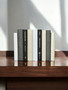 Natural, white, and gray parchment bound spines with a touch of modern hardbound books in black - (By the Foot)