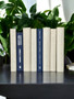 Natural parchment bound spines with a touch of modern hardbound books in varied blue tones for a very clean look. Book covers vary.- By the linear foot/ 8.5"-9.5"