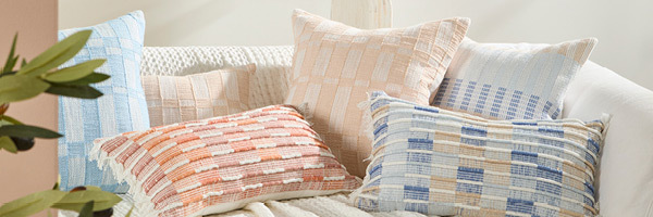 Picture features a variety of cushions in square and oblong sizes. Each cushion has a broken check design. 