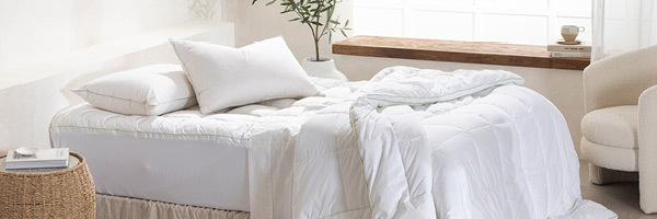 Picture features a bed with Greenfirst Hypoallergenic mattress topper, quilt and two pillows. 