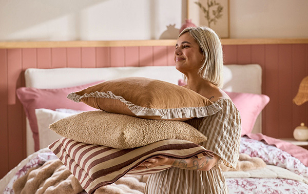 Roxy Stylist holding three cushions for styling from Pillow Talk