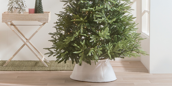 A Christmas tree with lights and a white tree skirt