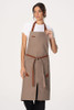 Front view of Fileas Bib Apron in taupe with contrasting brown neck strap