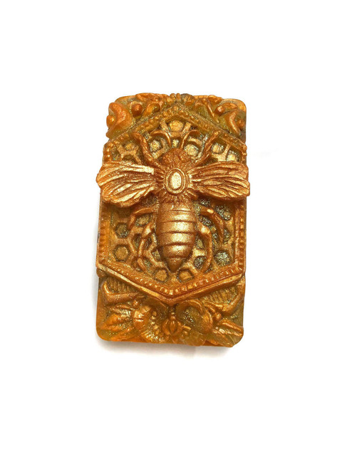 Beach City Boutique Filigree Calendula Bee Handcrafted Bee Soap resting on filigree design, shimmering with gold mica and adorned with calendula petals.